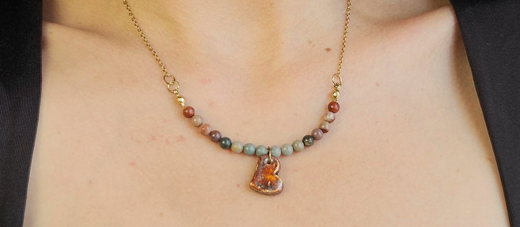 Ceramic heart pendant on a beaded necklace, worn