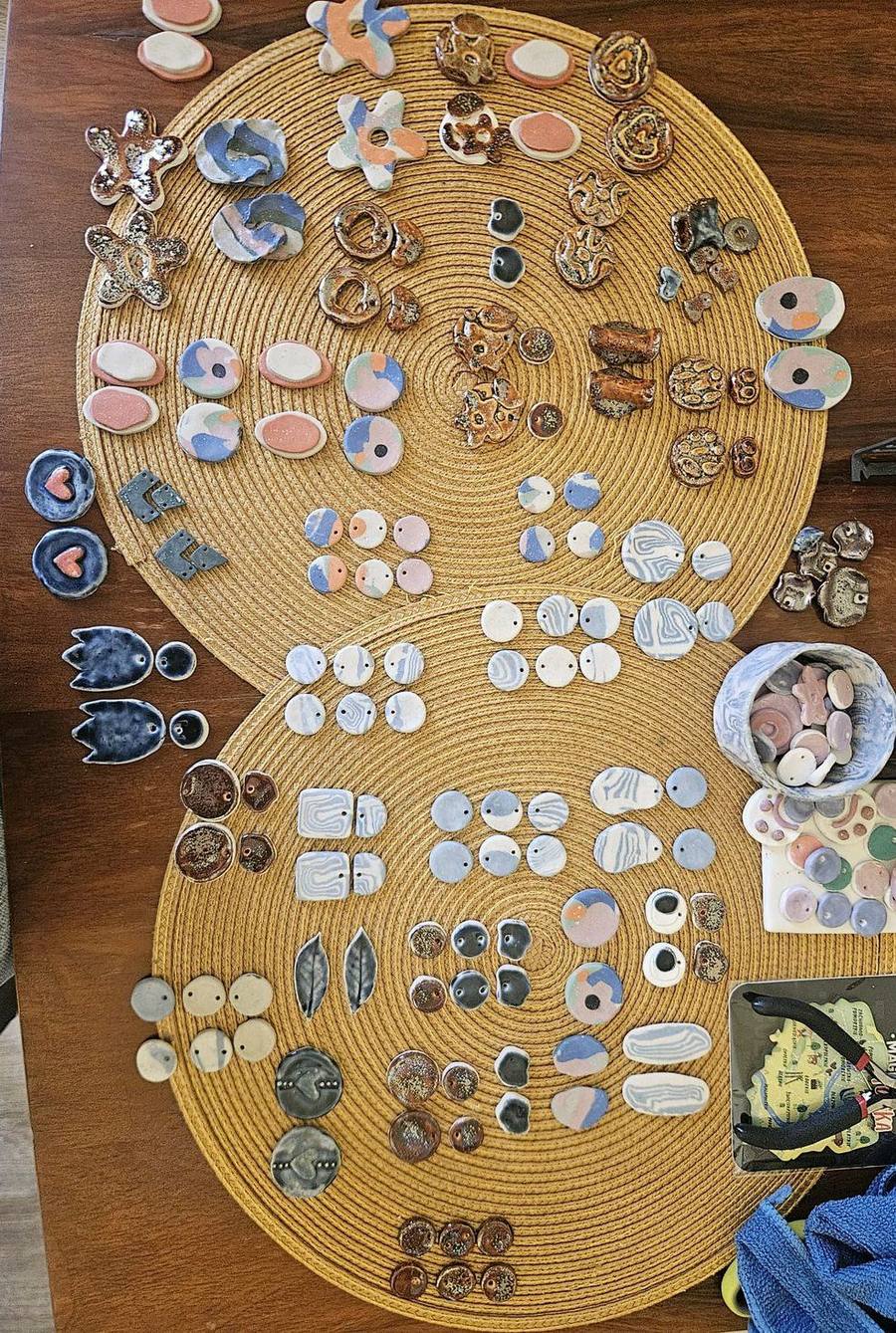 Large flat-lay of many ceramic jewelry pieces on jute mats