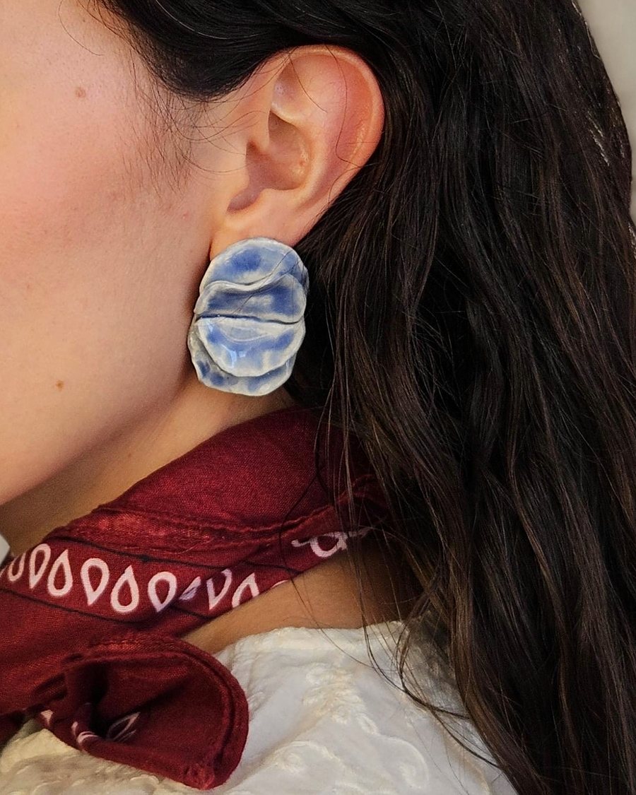 Blue-and-white folded stud earring, worn